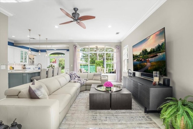 living room featuring ceiling fan and crown molding