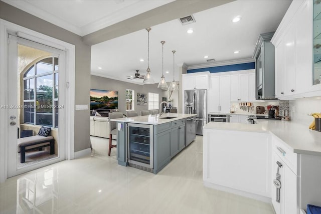 kitchen featuring pendant lighting, gray cabinetry, sink, stainless steel appliances, and beverage cooler