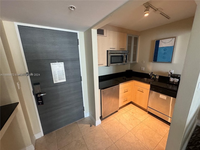 kitchen with light brown cabinets, sink, and appliances with stainless steel finishes