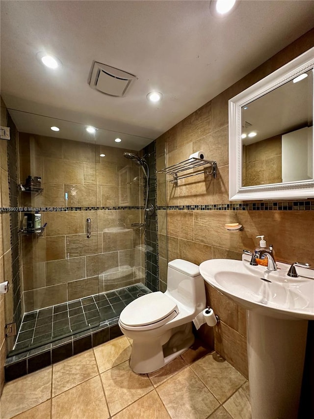 bathroom with toilet, an enclosed shower, tile walls, and tile patterned floors