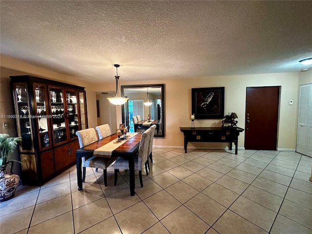 dining space featuring a textured ceiling and light tile patterned floors