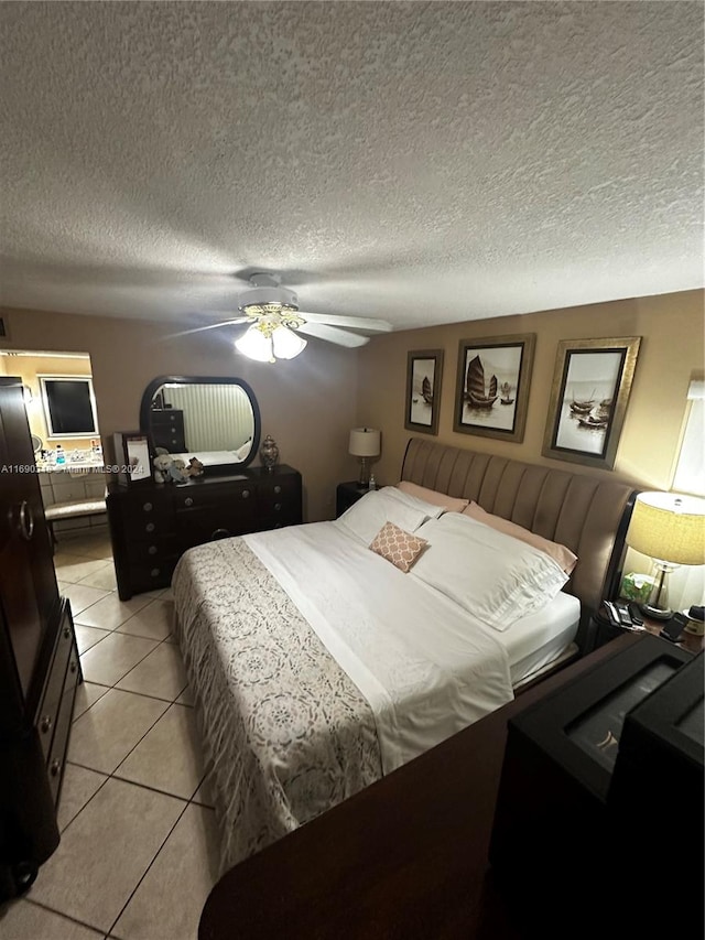 bedroom with a textured ceiling, ceiling fan, and light tile patterned flooring