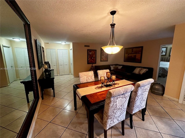 dining room featuring a textured ceiling and light tile patterned floors