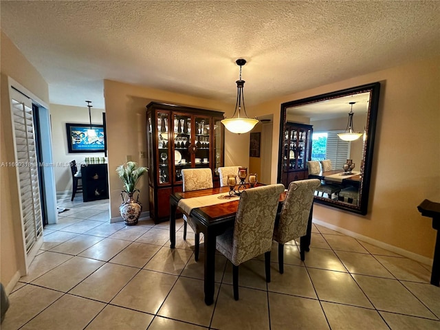 dining room featuring a textured ceiling and tile patterned floors