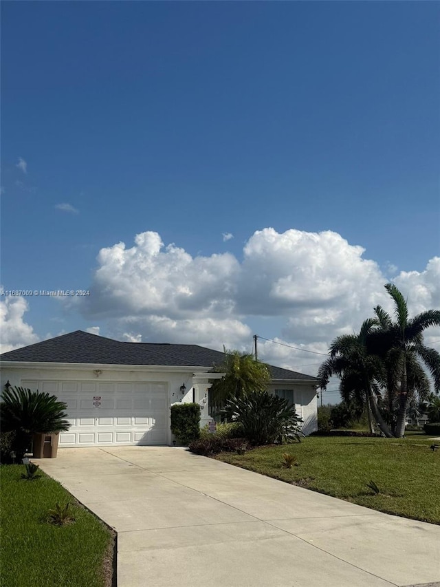 single story home featuring a front lawn and a garage