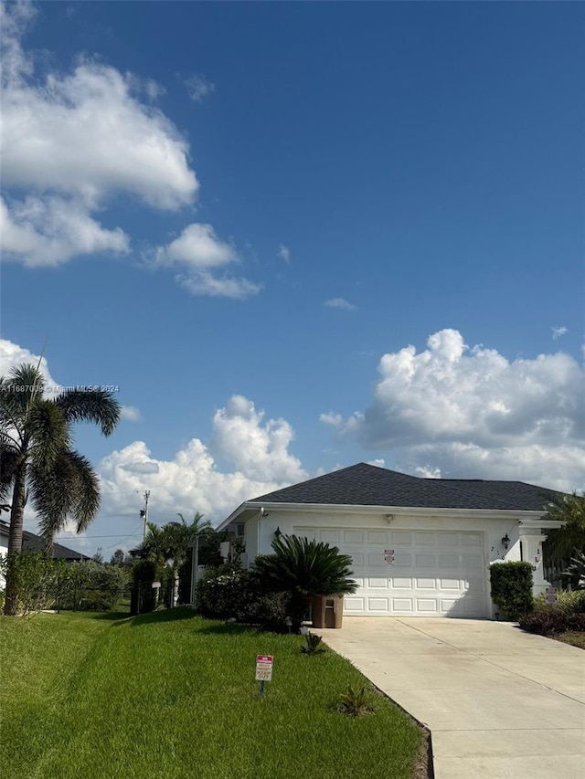 view of front of home with a garage and a front lawn