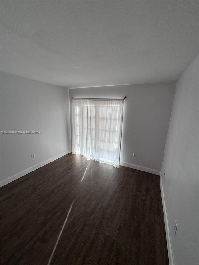 spare room featuring dark wood-type flooring