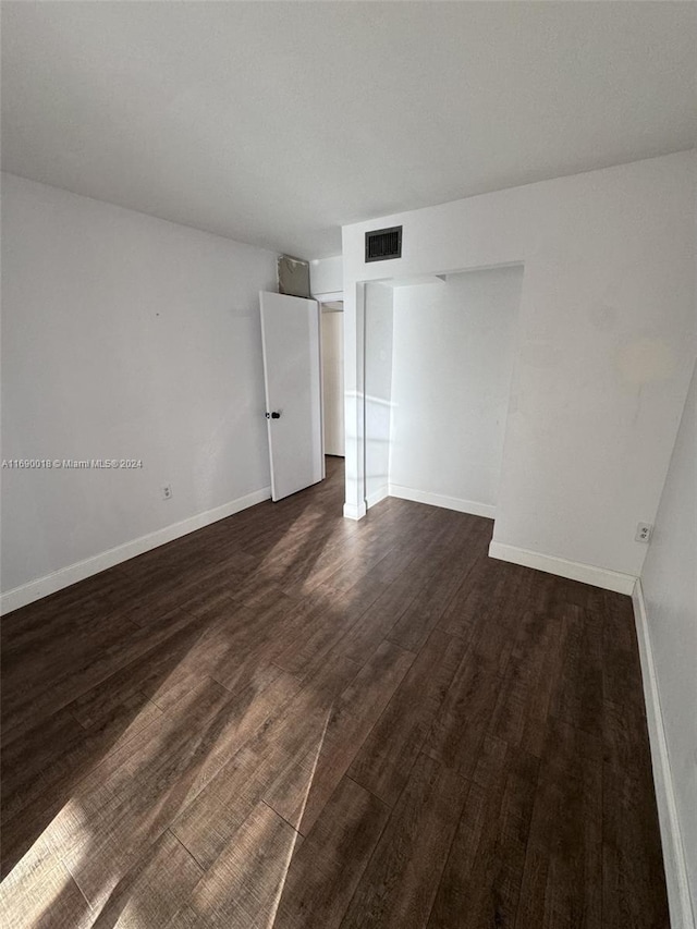 unfurnished bedroom with dark wood-type flooring