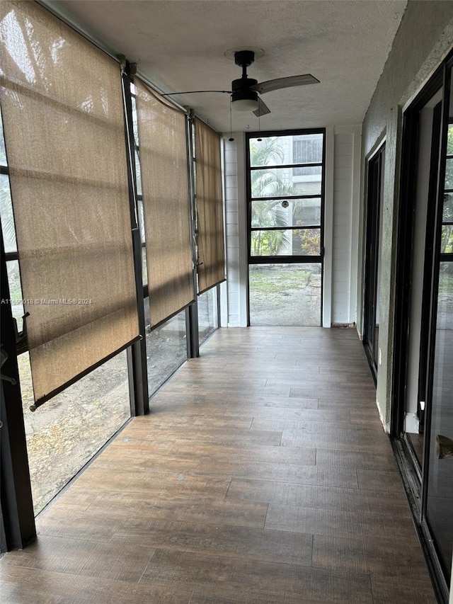 unfurnished sunroom with ceiling fan