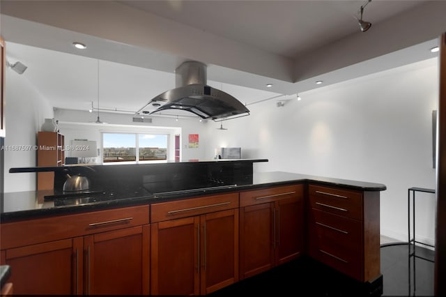 kitchen with island range hood, dark stone counters, kitchen peninsula, and black cooktop