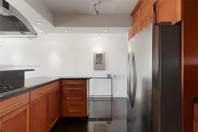 kitchen with extractor fan, black stovetop, and stainless steel refrigerator