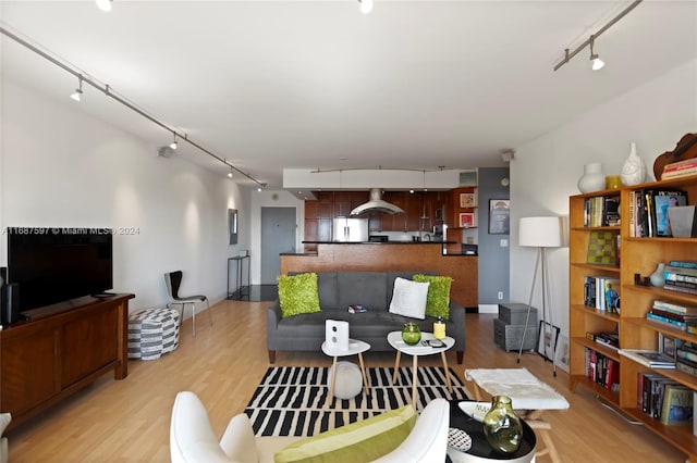 living room with track lighting and light hardwood / wood-style flooring