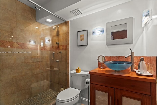 bathroom featuring vanity, toilet, and a shower with shower door