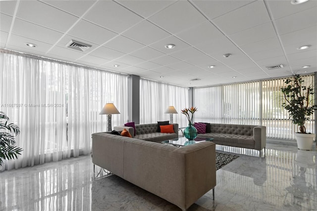 living room with expansive windows and a drop ceiling