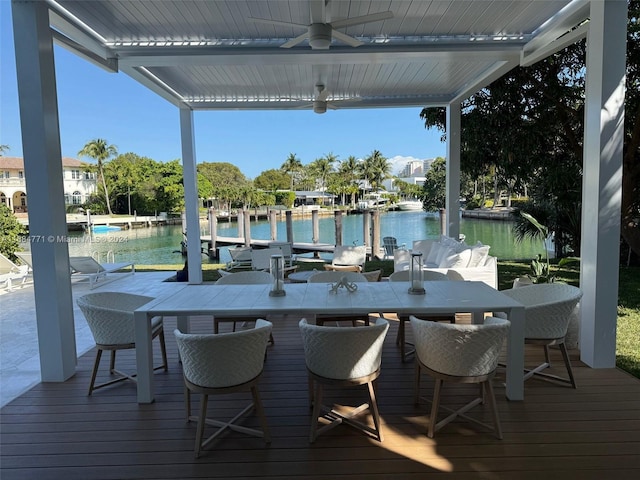 exterior space with a water view, a dock, and ceiling fan