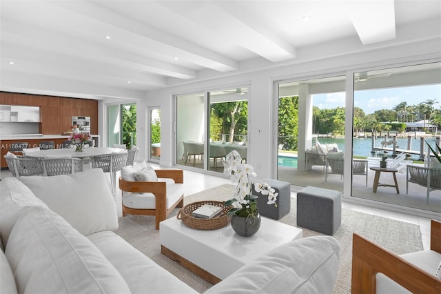 sunroom with beamed ceiling, a water view, and ceiling fan