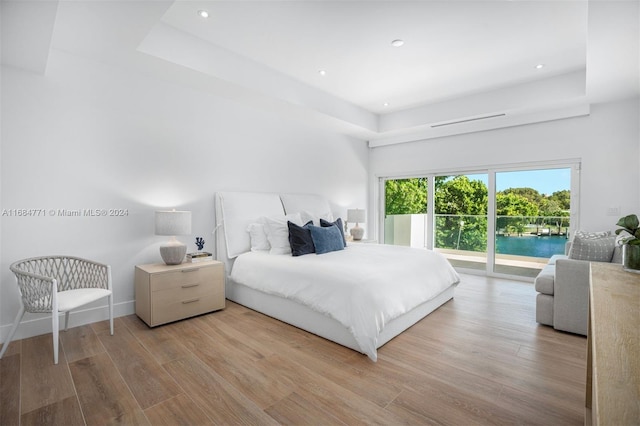 bedroom with access to exterior and light hardwood / wood-style flooring