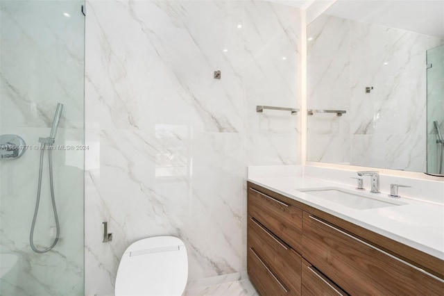 bathroom with a tile shower, vanity, toilet, and tile walls