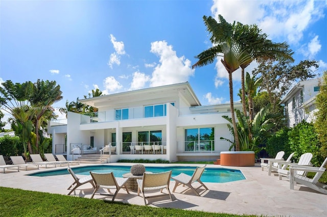 rear view of property featuring a balcony and a patio area