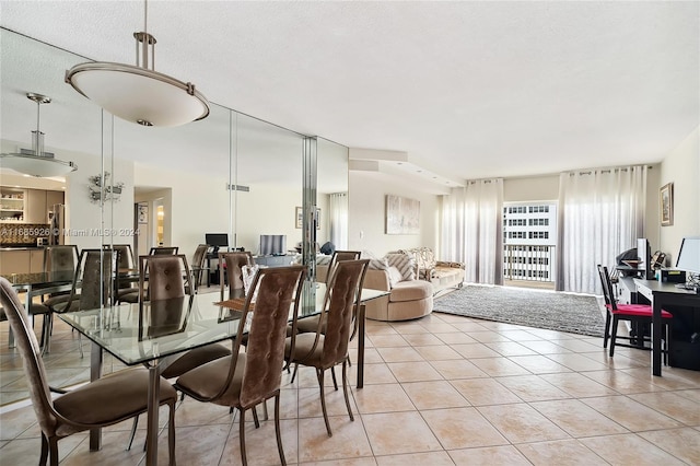 dining space featuring a textured ceiling and light tile patterned floors