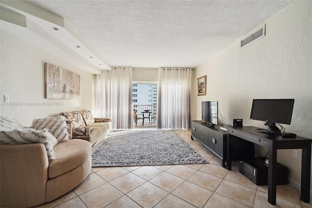 tiled living room featuring a textured ceiling