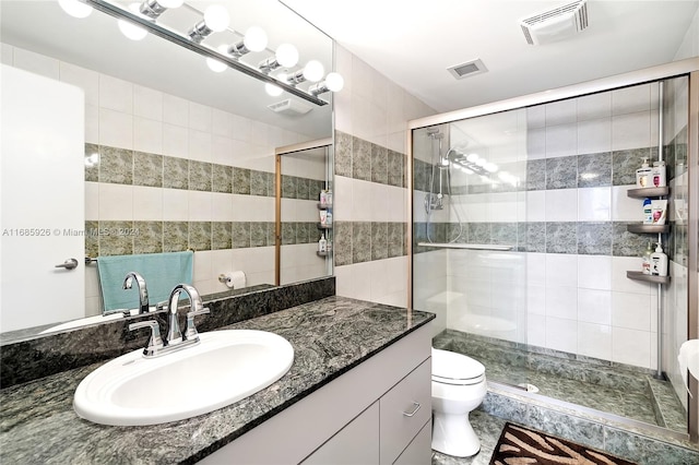 bathroom with vanity, toilet, and an enclosed shower