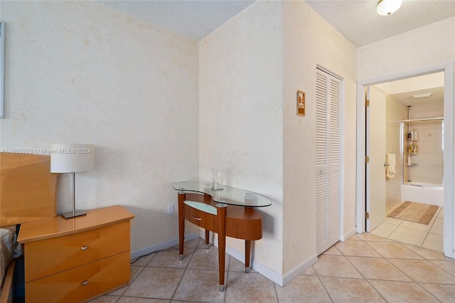 corridor featuring a textured ceiling and light tile patterned flooring