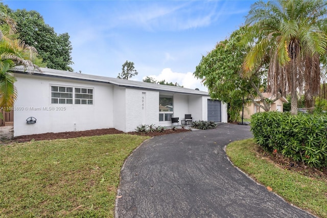 single story home featuring a front yard and a garage