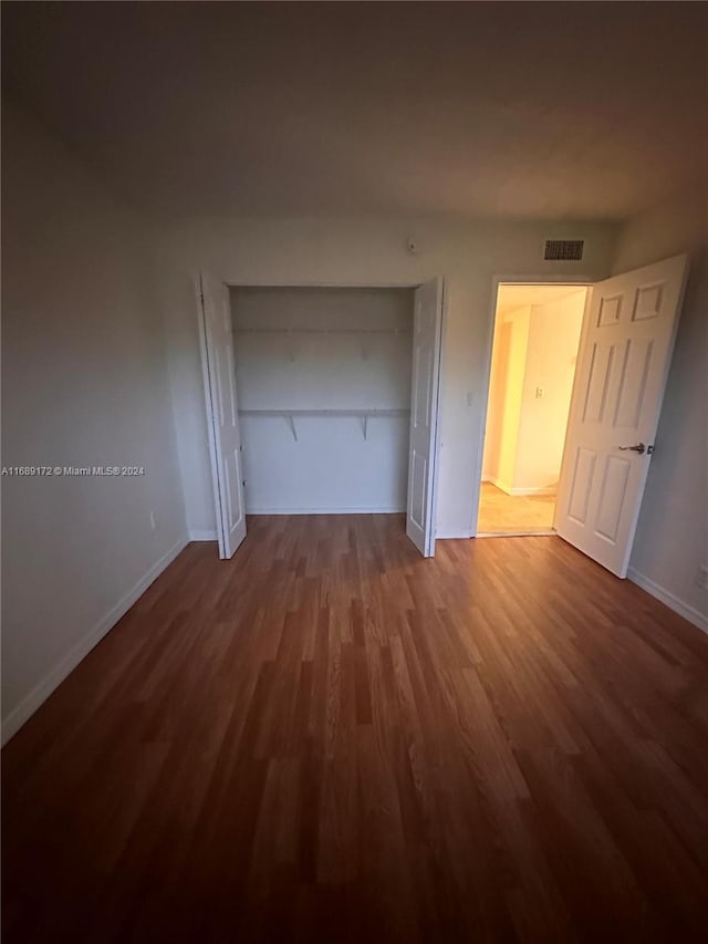 unfurnished bedroom featuring a closet and wood-type flooring