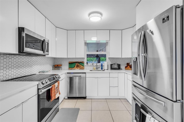 kitchen with appliances with stainless steel finishes, white cabinets, and sink