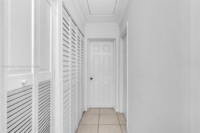 hall with light tile patterned floors and crown molding