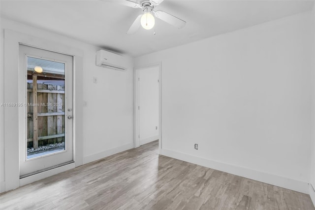 unfurnished room featuring ceiling fan, a wall unit AC, and light wood-type flooring