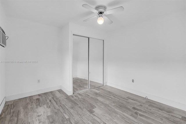 unfurnished bedroom featuring ceiling fan, a closet, and light wood-type flooring