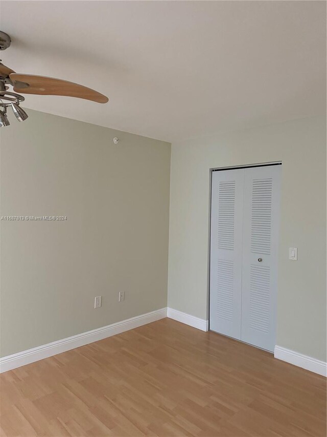 unfurnished bedroom featuring a closet, light wood-type flooring, and ceiling fan