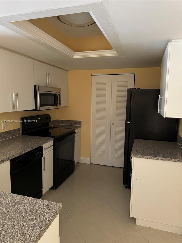 kitchen with white cabinets, black appliances, and a tray ceiling