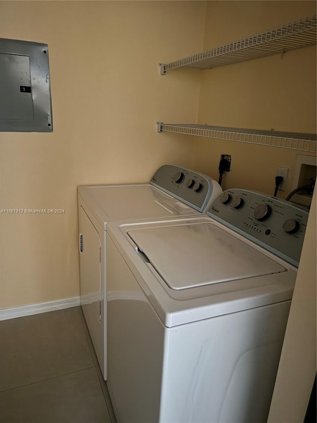 clothes washing area with tile patterned floors, electric panel, and washer and dryer