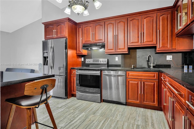 kitchen featuring lofted ceiling, sink, decorative backsplash, and appliances with stainless steel finishes