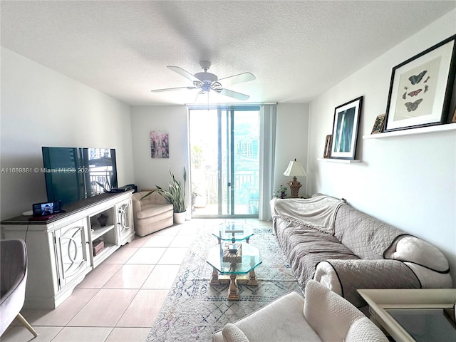 living room featuring light tile patterned floors, a textured ceiling, and ceiling fan