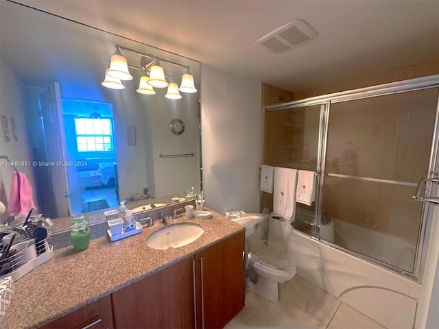 full bathroom with toilet, vanity, tile patterned floors, and bath / shower combo with glass door