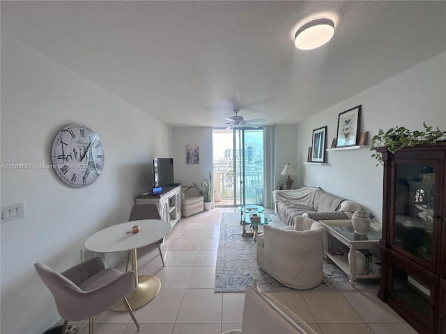 living room with light tile patterned floors, a textured ceiling, and ceiling fan