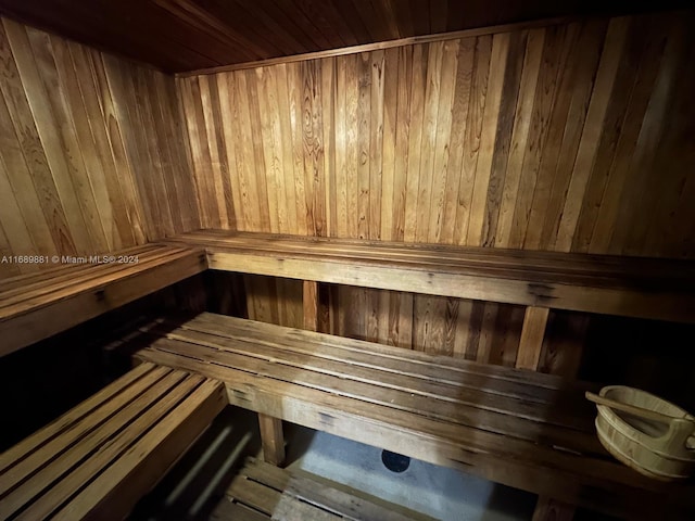 view of sauna featuring wood ceiling and wood walls