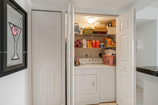 washroom with washer and clothes dryer and light tile patterned floors