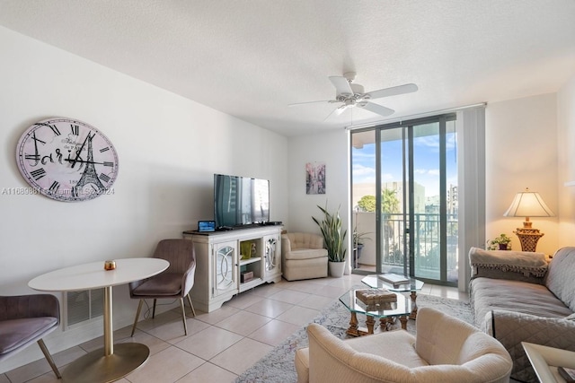 tiled living room with a textured ceiling, a wall of windows, and ceiling fan