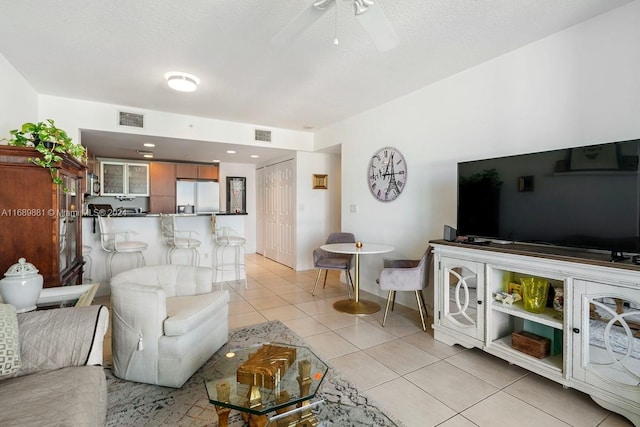 tiled living room featuring a textured ceiling and ceiling fan