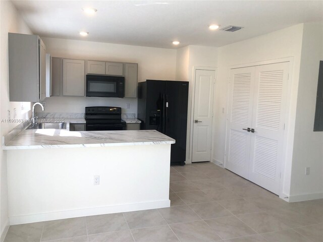 kitchen featuring sink, light tile patterned floors, gray cabinets, black appliances, and kitchen peninsula