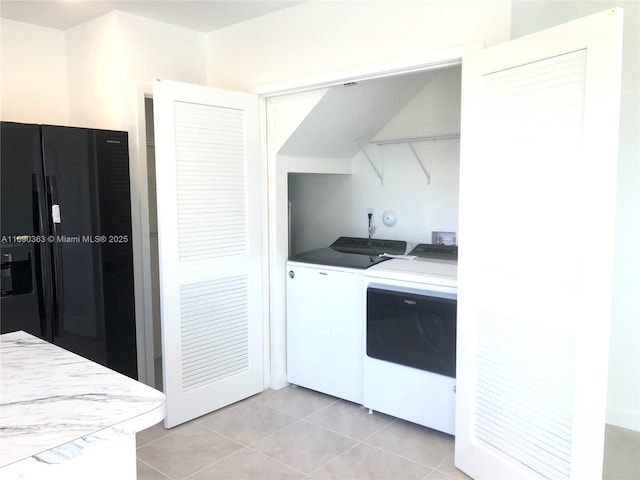 laundry area featuring washer and clothes dryer and light tile patterned floors