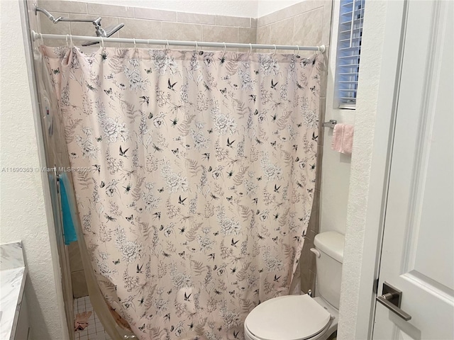 bathroom featuring a shower with shower curtain and toilet