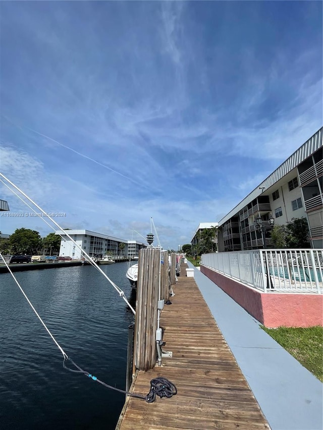 view of dock with a swimming pool and a water view