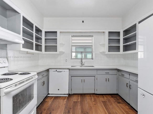 kitchen with gray cabinetry, white appliances, sink, dark hardwood / wood-style floors, and tasteful backsplash