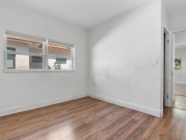 spare room with hardwood / wood-style floors and a healthy amount of sunlight